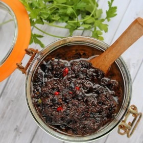 Hausgemachte schwarze Bohnensauce in einem Glas mit Holzlöffel, ideal für asiatische Gerichte und Dips.